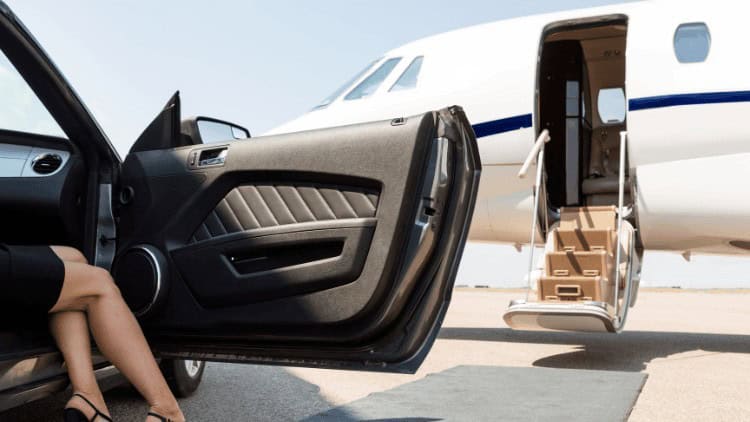 Woman getting out of luxury car into private jet