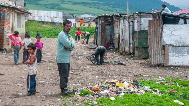 Reinvigorating the European Social Charter Roma man and children standing amid hovels and rubbish