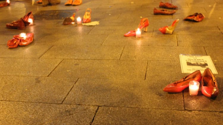 Femicide: why a specific crime is needed red shoes and candles in a public square