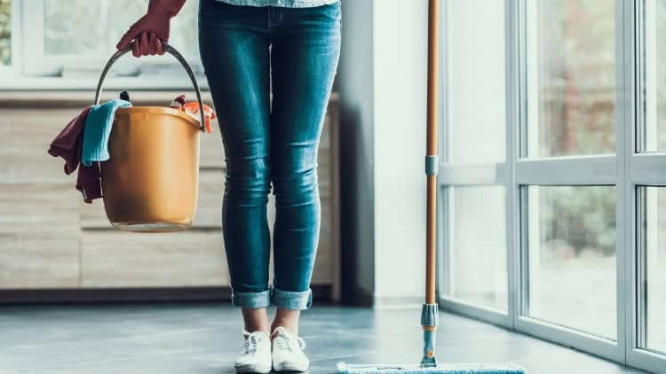 woman carrying cleaning equipment in kitchen