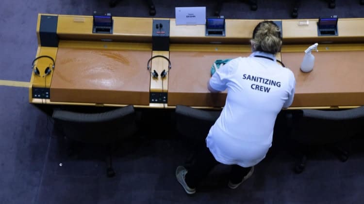 Cleaners come out from the shadows to mobilise Cleaner sanitising seats and benches in the European Parliament