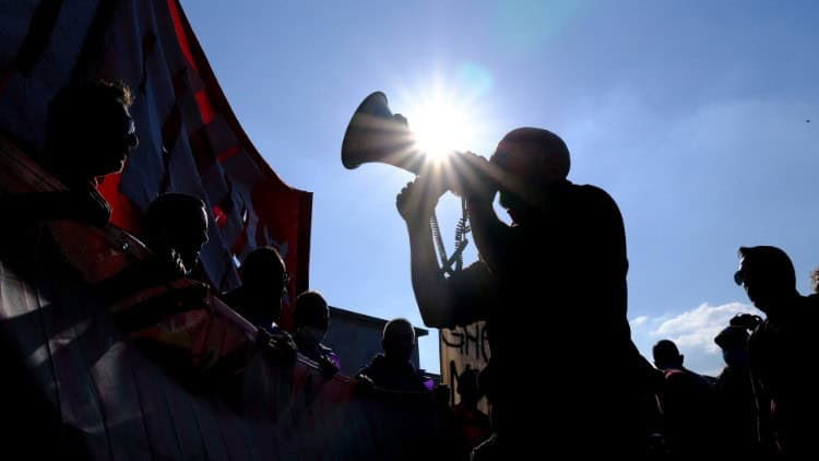 European Social Charter—political will needed Stylised image of trade-union demonstration, with figures silhouetted against the sun, one speaking into a megaphone