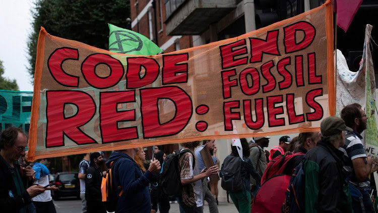 How Big Oil gaslights Europe on climate policy Demonstrators with big banner saying 'Code Red: End Fossil Fuels'