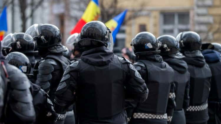 Rebuilding trust in democracy in Moldova Lots of riot police in uniforms and helmets facing demonstrators carrying Moldovan flags