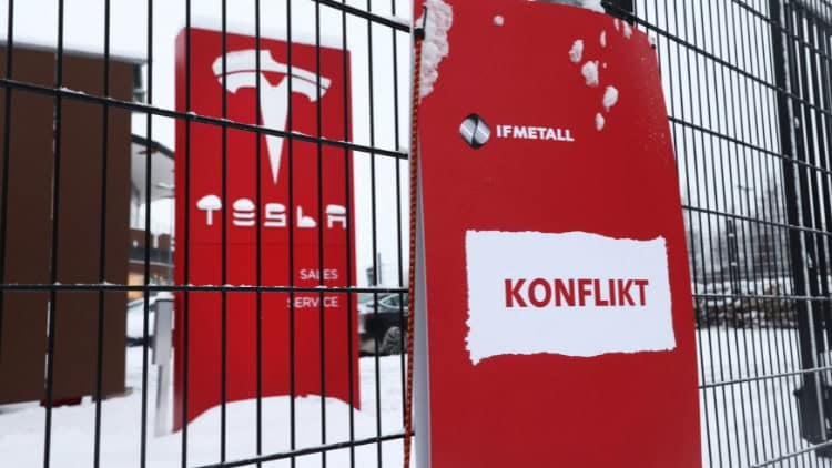 The Tesla dispute: a new frontier? Fence with Tesla sign on one side and IF Metall sign on the other
