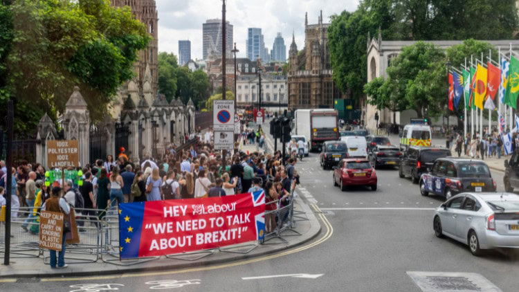 What should Labour aim for in Europe? banner saying 'Hey Labour: we need to talk about Brexit!' near Houses of Parliament