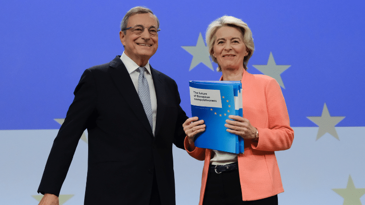 ‘Better regulation’? Capital first, society second Smiling man and woman presenting report against backdrop of EU stars