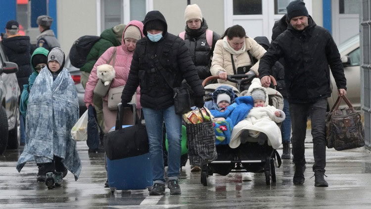 Incentives in reverse: returning Ukrainian refugees Bedraggled group woth two babies, a child and a pet, carrying what personal goods they can.
